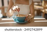 Cafe bliss, young woman enjoys leisurely coffee break, reveling in the sunny interior of a cafeteria, sitting, delicately stirring her drink indoors, closeup showcasing the relaxation