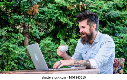 Cafe ensuring comfortable Internet use. Bearded man drinking and browsing the Web in cafe. Hipster enjoying tea and free wifi in cafe. Cyber cafe providing Internet access and freshly brewed coffee. - Powered by Shutterstock