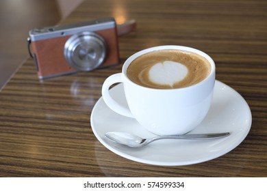 Cafe latte and digital camera on table