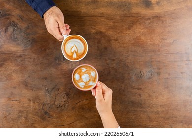 Cafe latte, top view of two mugs cafe latte. Couple sitting on the wooden table in cafe. Drinking coffee with latte art. Copy space background for menu design, beautiful coffee shop concept idea. - Powered by Shutterstock