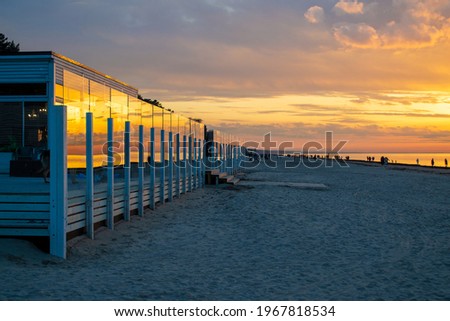 Cafe on beach during sunset. Beautiful colorful clouds over Baltic sea in Jurmala resort, Latvia. Relax, vacation concept.