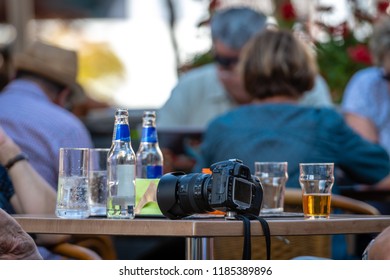 In the cafe on the table placed a camera, bottles and glasses.