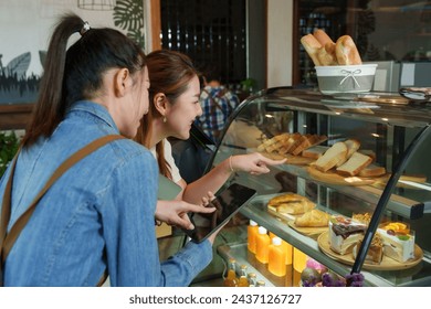 Cafe owner, small business, Asian woman, barista Taking orders from tablets business woman customer white shirt stands selects points front bakery  bread cabinet shop promotion sign minimalist style. - Powered by Shutterstock