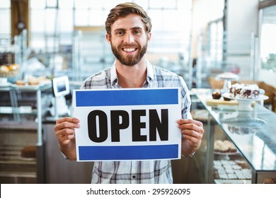 Cafe owner smiling at the camera at the cafe - Powered by Shutterstock