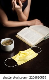 Cafe And Pandemic. Medical Mask, Cup And Open Book. Dark Background. End Of Quarantine.