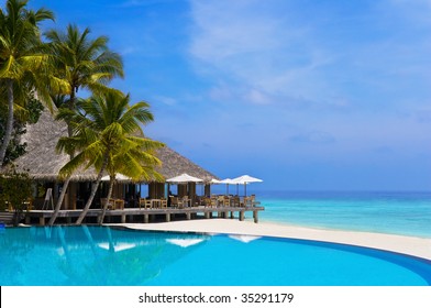 Cafe and pool on a tropical beach - travel background - Powered by Shutterstock