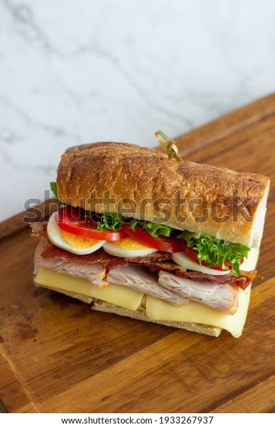 Cafe -\
Sandwich with bacon, cheese, ham and\
vegetables
