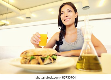 Cafe Woman Eating Sandwich And Drinking Juice. Cute Young Asian Woman.