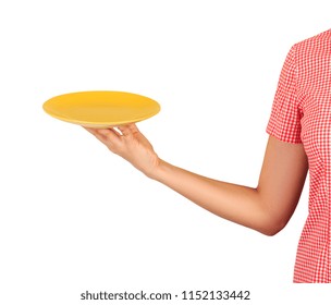 cafe worker points at the camera with an empty round yellow plate in front of him. perspective view.
