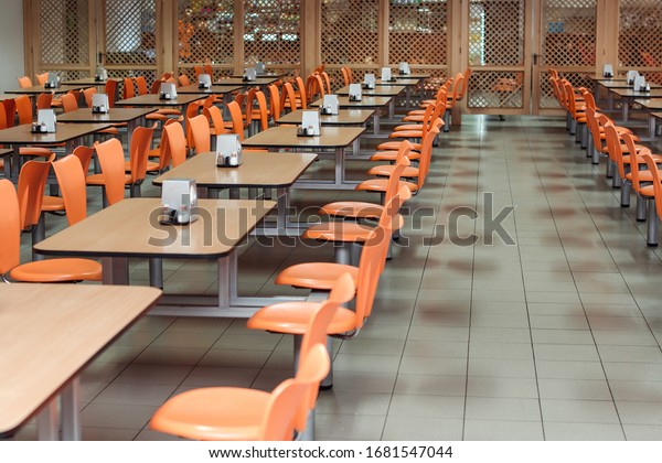 Cafeteria or canteen interior.\
School cafeteria. Factory canteen with chairs and tables, nobody.\
Modern cafeteria interior. Clean canteen in modern school. Lunch\
room.