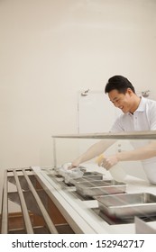 Cafeteria Worker Cleaning Food Serving Area