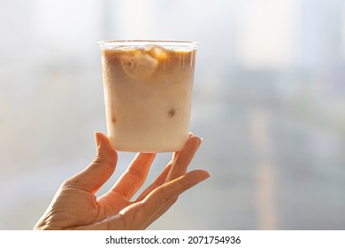 caffe latte in glass in woman hand