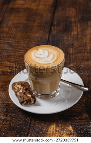 Caffe latte with leaf latte art served on wooden table