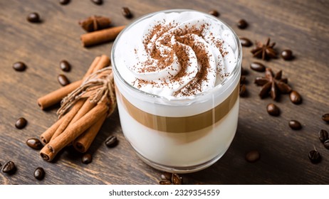 caffe latte with whipped cream, cinnamon and anise in a glass