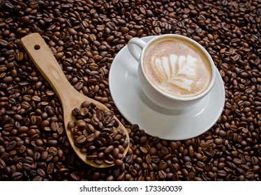 caffe latte with wood scoop and coffee beans