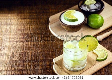 Caipirinha, drink from Brazil, typical of the Brazilian summer. Fruit drink with vodka or cachaça, on rustic wooden background and space for text.