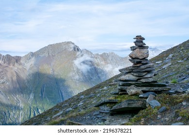 A cairn (also called stone man or stone mandl) in the Austrian Alps used as a trekking path sign.