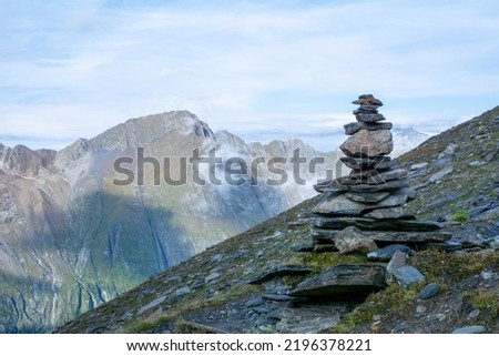 A cairn (also called stone man or stone mandl) in the Austrian Alps used as a trekking path sign.