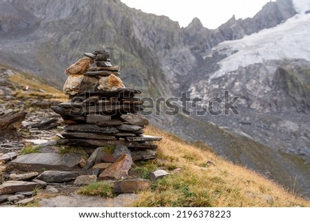 A cairn (also called stone man or stone mandl) in the Austrian Alps used as a trekking path sign.
