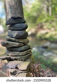 Cairn By Stream Blurred Background