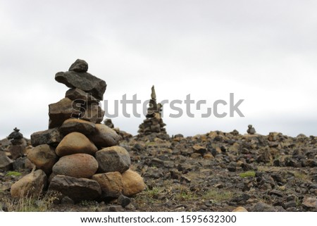Cairn rock pile with blurry background of rocky brown mountainside in Iceland