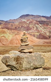 Cairn Rock Stack In Front Of Mountain With Colorful Layers