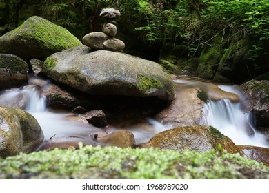 Cairn With Silky Water Stream Waterfall In The Forest