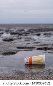 Cairns, Australia - June 16, 2019: McDonald's Cup Littered On Sandy Beach.