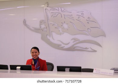 CAIRNS, AUSTRALIA – OCTOBER 31 2013: An Unidentified Smiling Virgin Australia Employee Welcomes Guests Into The Airline's New Lounge At Cairns Airport.