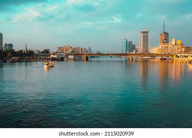 Cairo Egypt December 2021 View of the amazing Nile river at sunrise, boats anchored on the shores. Bright blue river and sky colors. Skyscrappers in the distance