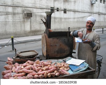 Cairo, Egypt – February 28, 2007: A street vendor sells hot potatoes baked in a traditional, mobile oven attached to a bicycle in the center of Cairo. 