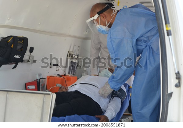 Cairo, Egypt, July 7 2021: Egyptian medical health\
workers team dealing with an emergency case inside an equipped\
ambulance in the street and the patient is connected to the vital\
signs monitor 