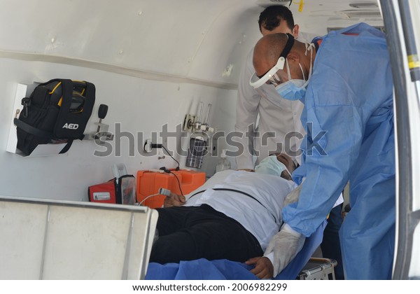 Cairo, Egypt, July 7 2021: Egyptian medical health
workers team dealing with an emergency case inside an equipped
ambulance in the street and the patient is connected to the vital
signs monitor 