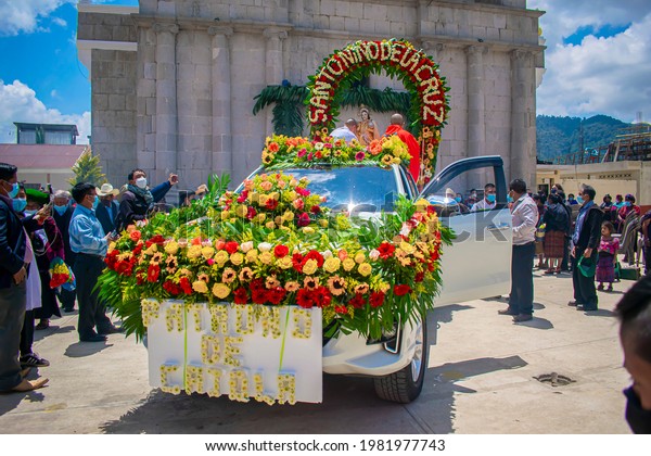 cajola, quetzaltenango, guatemala, may 1,\
2021, car with sign honoring saint child of the cross, with flower\
decoration with church\
background
