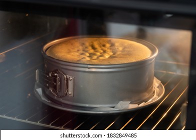 a cake bakes in a round springform pan in a lighted oven in an apartment