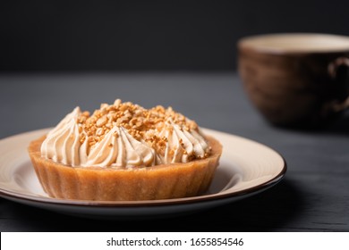 Cake Basket With Salted Caramel And Golden Balls On The Background Of A Cup Of Coffee.