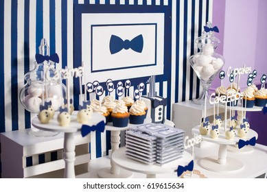 Cake, candies, marshmallows, cakepops, chocolate and other sweets on dessert table at kids birthday party. Birthday Dessert celebration candy bar in white and blue colors.