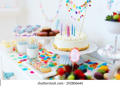 Cake, candies, marshmallows, cakepops, fruits and other sweets on dessert table at kids birthday party - Shutterstock ID 292806644