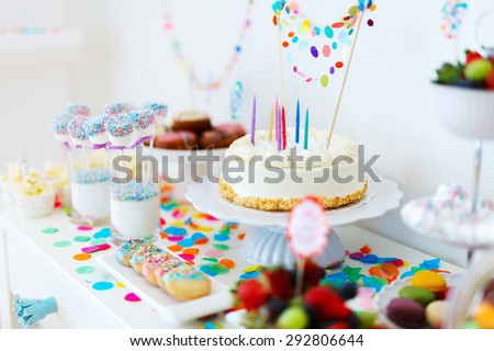 Cake, candies, marshmallows, cakepops, fruits and other sweets on dessert table at kids birthday party