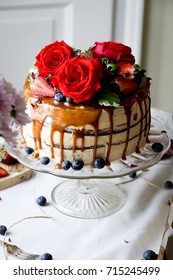 A Cake With Caramel Drizzle And Red Roses 