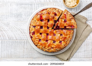 Cake with cranberry jam and almonds, lattice design on top.  White wooden table. Homemade.  - Powered by Shutterstock