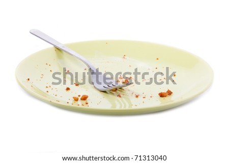 Cake crumbs and fork on yellow plate isolated on white background