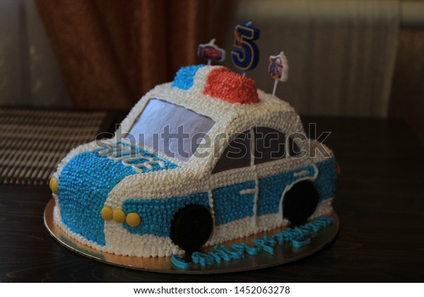 Cake in the form of a police car with the\
inscription Happy\
Birthday.