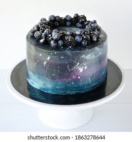 Cake With The Image Of The Cosmos Drawn By Airbrush Decorated Blueberries, Blackberry. Galaxy, Stars In The Night Sky. Cutout.