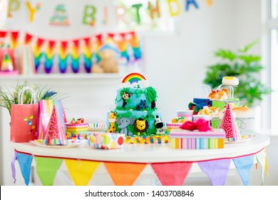 Cake For Kids Birthday Celebration. Jungle Animals Theme Children Party. Decorated Room For Boy Or Girl Kid Birthday. Table Setting With Presents, Gift Boxes, Confetti And Sweets. Pastry For Child