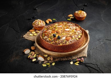 Cake. Mawa Cake is a rich, delicious cake made with mawa and atta. Serve on wooden texture background with muffins, dry fruit nuts. Homemade mawa cake. Almond, Cashew, Blackberry, Pistachio. - Powered by Shutterstock