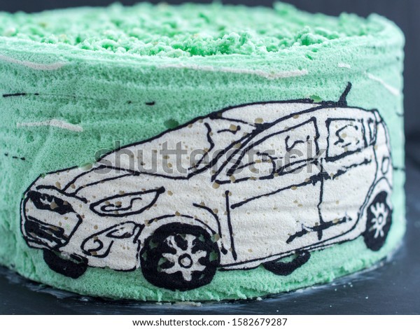 \
cake with a picture of a white car in blue and\
green pastel colors