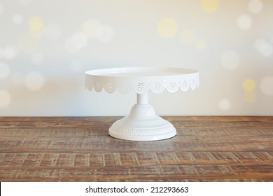 Cake plate on vintage wooden table over bokeh background