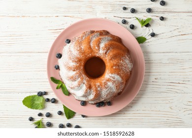 Cake with powder sugar and blueberry on wooden background, top view - Powered by Shutterstock