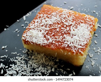 Cake Slice On A Dark Background With Coconut Powder, Semolina Dessert 